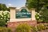 Inviting entrance sign for Hollow Run Apartments, surrounded by lush greenery and vibrant flowers, exuding a welcoming atmosphere.