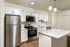 Sleek modern kitchen featuring stainless steel appliances, elegant white cabinetry, and a spacious marble countertop island.