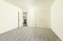 Bright, airy room with plush carpet, white double doors, and a view into a modern kitchen.