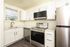 Elegant modern kitchen with stainless steel appliances, white cabinetry, and sleek countertops, offering a bright, stylish cooking experience.