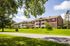 Charming apartment complex nestled in lush greenery with spacious balconies and a peaceful suburban setting.