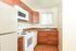 Bright and modern kitchen featuring elegant wooden cabinetry, sleek countertops, and a built-in microwave.