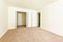 Bright and spacious room with plush beige carpet, double-door closet, and crisp white walls, ideal for versatile living.