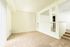 Bright, open-concept living space with plush beige carpeting, white walls, and stylish interior railing design.