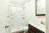 Bright and modern bathroom featuring a sleek shower, elegant sink with a stylish vanity, and a large framed mirror.