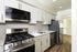Modern kitchen with sleek stainless steel appliances, white cabinetry, and elegant tile backsplash.