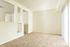 Bright and spacious living area with plush carpet and large windows, perfect for natural light lovers.