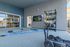 Modern fitness area with TRX system, kettlebells, and mounted TV in a spacious, well-lit apartment complex gym.