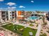 Vibrant apartment complex showcasing modern architecture, lush green spaces, and a sparkling pool under a clear blue sky.
