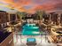Luxury apartment complex with stunning sunset views, featuring a sparkling pool, elegant lounge areas, and modern architectural design.
