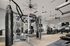 Spacious and modern fitness center equipped with state-of-the-art gym machines, punching bag, and sleek interior design, perfect for achieving fitness goals.