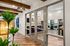 Modern apartment interior featuring wooden beams, stylish pendant lighting, and a sleek communal space visible through glass doors.