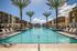 Luxurious apartment community showcasing a stunning pool with palm trees and modern architecture, perfect for relaxation and leisure.
