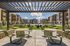 Modern apartment complex with vibrant architecture, featuring a spacious outdoor seating area, perfect for social gatherings, under a clear blue sky.