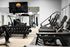 Modern fitness center with state-of-the-art treadmills, weight racks, and sleek workout equipment beneath a stylish Origin logo.
