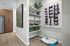 Modern apartment corner features sleek wood cabinets, open shelving with decorative accents, and contemporary art, creating a stylish and inviting space.