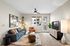 Modern living room with stylish decor, featuring a cozy sofa, vibrant accent chair, and sleek entertainment unit with a flat-screen TV. Bright, airy space with large windows and elegant lighting.