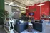 Stylish modern lounge with leather seating and plants, featuring a vibrant red accent wall and industrial decor.