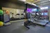 Modern fitness center with treadmills, exercise bikes, and large mirrors.
