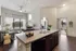 Modern open-plan kitchen with sleek granite countertops, inviting living area with natural light, and elegant pendant lighting creating a warm atmosphere.