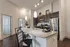 Modern kitchen with elegant granite countertops, sleek stainless steel appliances, pendant lighting, and stylish dark wood cabinetry, creating a warm and inviting space.
