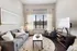 Charming living room with a cozy gray sofa, stylish armchair, and elegant wall art, basked in natural light from expansive windows.