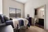 Cozy bedroom with a stylish navy and white decor, featuring a window with serene views and an ensuite bathroom.
