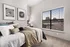 Elegant bedroom with a cozy bed, stylish decor, and large windows offering a picturesque view.