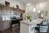 Modern kitchen with sleek dark wood cabinets, stainless steel appliances, and elegant countertops. Bright lighting and contemporary design make it inviting and stylish.
