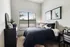 Cozy bedroom with modern decor, featuring stylish art, elegant furnishings, and a large window for natural light.