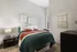 Inviting bedroom with cozy bedding, stylish wall art, and warm ambiance.