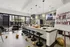 Modern community space featuring a chic kitchen bar with stylish seating, elegant lighting, and a grand re-opening sign at Domain at Northgate, ready for a vibrant gathering.