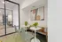 Cozy apartment nook featuring modern chairs, stylish round tables with vibrant flower arrangements, and contemporary abstract artwork on the walls.