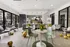 Chic community space with modern decor, stylish seating, and bright yellow floral arrangements. Features large windows providing abundant natural light, ideal for social gatherings.