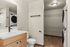 Modern bathroom with sleek fixtures and integrated laundry area featuring a stacked washer and dryer.