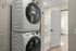 Modern apartment featuring a convenient in-unit washer and dryer next to a sleek bathroom with tub, offering comfort and style.