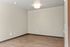 Bright empty room with elegant wood flooring and modern ceiling light, ready for customization and personal style.