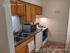 Charming kitchen with modern updates at 20 College Drive, featuring sleek countertops, wooden cabinetry, and a cozy layout ideal for culinary creativity in a 2-bedroom apartment.