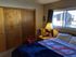 Cozy one-bedroom apartment featuring a comfortable bed, warm lighting, and a large window providing natural light.