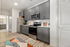 Kitchen with stainless steel appliances in Auburn apartment. Modern kitchen with sleek gray cabinets, stainless steel appliances, and stylish wood flooring.