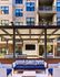 Outdoor entertainment space Auburn student housing. Modern outdoor lounge area with stylish seating and decorative pergola, string lights, and vibrant cushions against apartment backdrop.