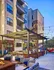Evening courtyard Auburn student apartments. Modern apartment building with vibrant outdoor seating, sleek pergola, and inviting string lights, perfect for relaxation and socializing.