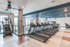 Apartment gym with treadmills Auburn University. Modern fitness center with multiple treadmills and exercise equipment in a bright, spacious area with large windows.