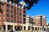 Exterior of 320 West Mag student apartments in Auburn AL. Modern urban living at its finest in a stylish brick apartment building, featuring contemporary design and convenient street-level retail spaces.