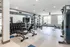 Gym with weights in Auburn student housing. Modern fitness center featuring state-of-the-art gym equipment, weights, and bright spacious interiors.