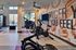 Cardio equipment and workout space in Auburn student housing gym. Inviting fitness center with modern exercise equipment and motivational wall art, offering a bright and inspiring workout environment.