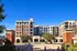 Exterior of 320 West Mag student apartments in Auburn AL. Elegant brick apartment complex with modern architecture, featuring a welcoming entrance and lush greenery in a vibrant urban setting.