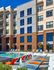 Pool deck with lounge chairs at Auburn student housing. Modern apartment complex with stylish brick facade and luxurious outdoor pool area featuring vibrant lounge chairs and serene water features.