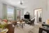 Inviting living room with plush beige sectional, elegant decor, and modern entertainment setup, featuring bright natural light and a stylish gray accent chair.