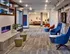 Resident lounge with fireplace in Auburn student housing. Inviting modern lobby area with stylish seating, artistic decor, and cozy lighting, perfect for welcoming guests.